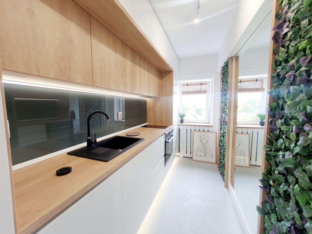 Bright minimalist kitchen with wooden elements and green decor.