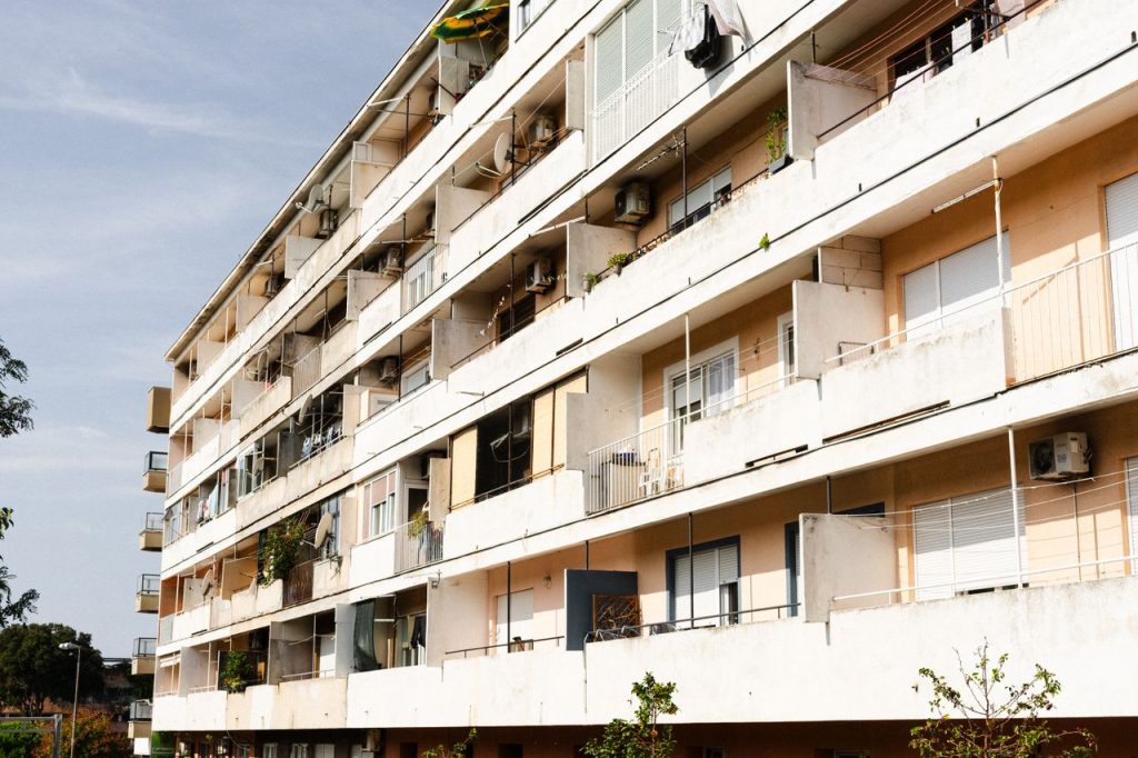 Multi-story apartment building with balconies on a sunny day.