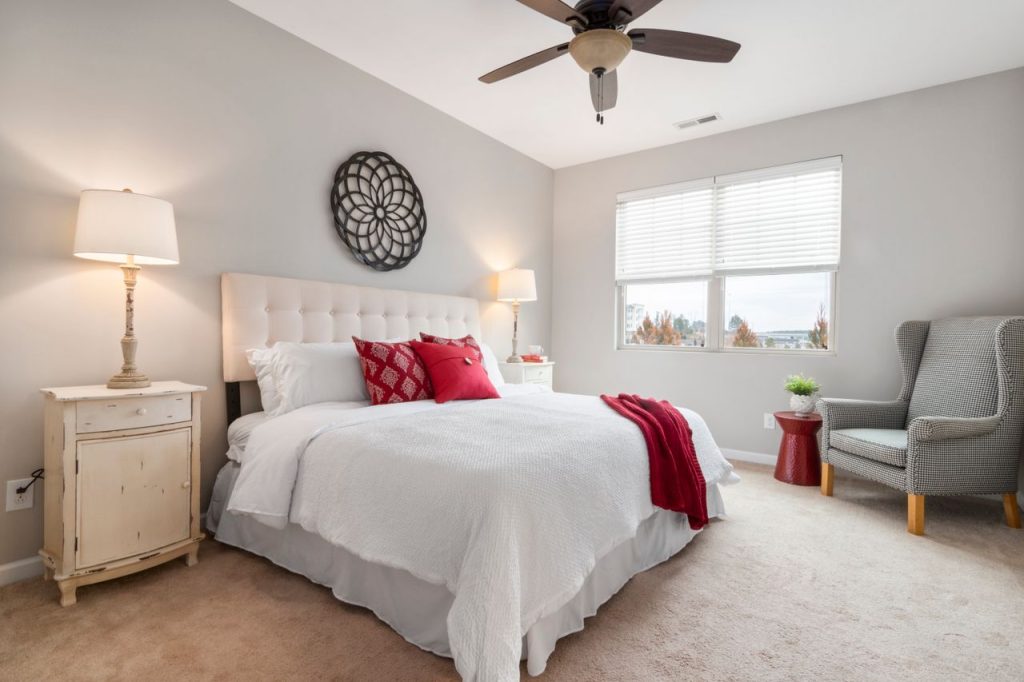 Spacious modern bedroom featuring cozy red accents and elegant decor.