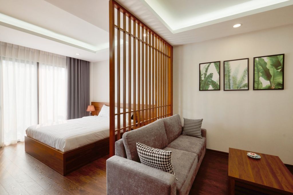Stylish minimalist bedroom and living space with wooden elements and modern decor.